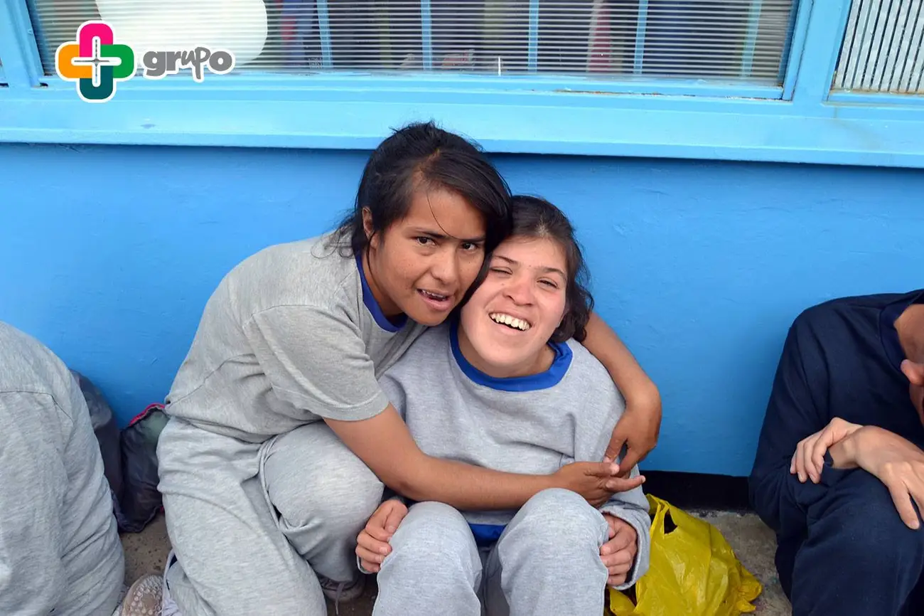 Dos personas abrazadas frente a la cámara