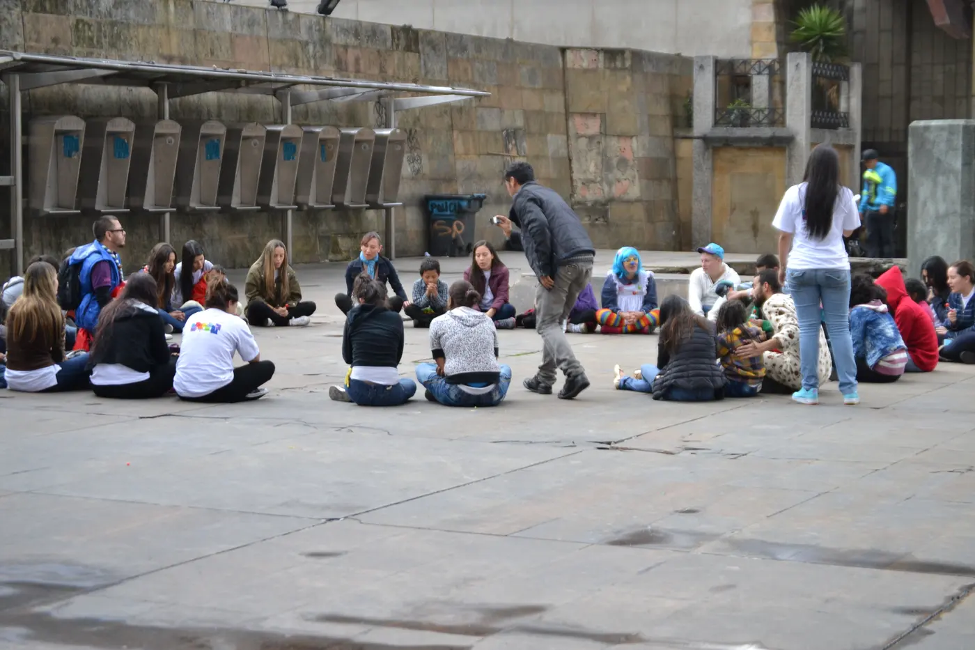Vista amplia del grupo sentado en la plaza